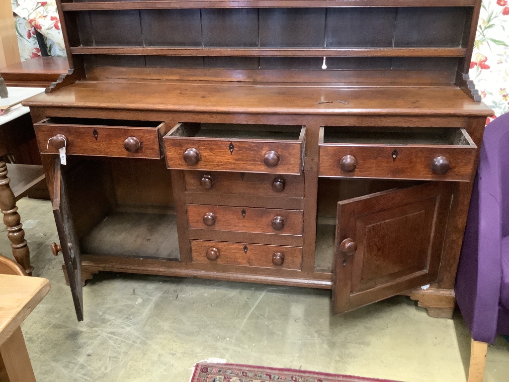 An early 19th century oak dresser with boarded rack, W-174, D-48, H-210cm.